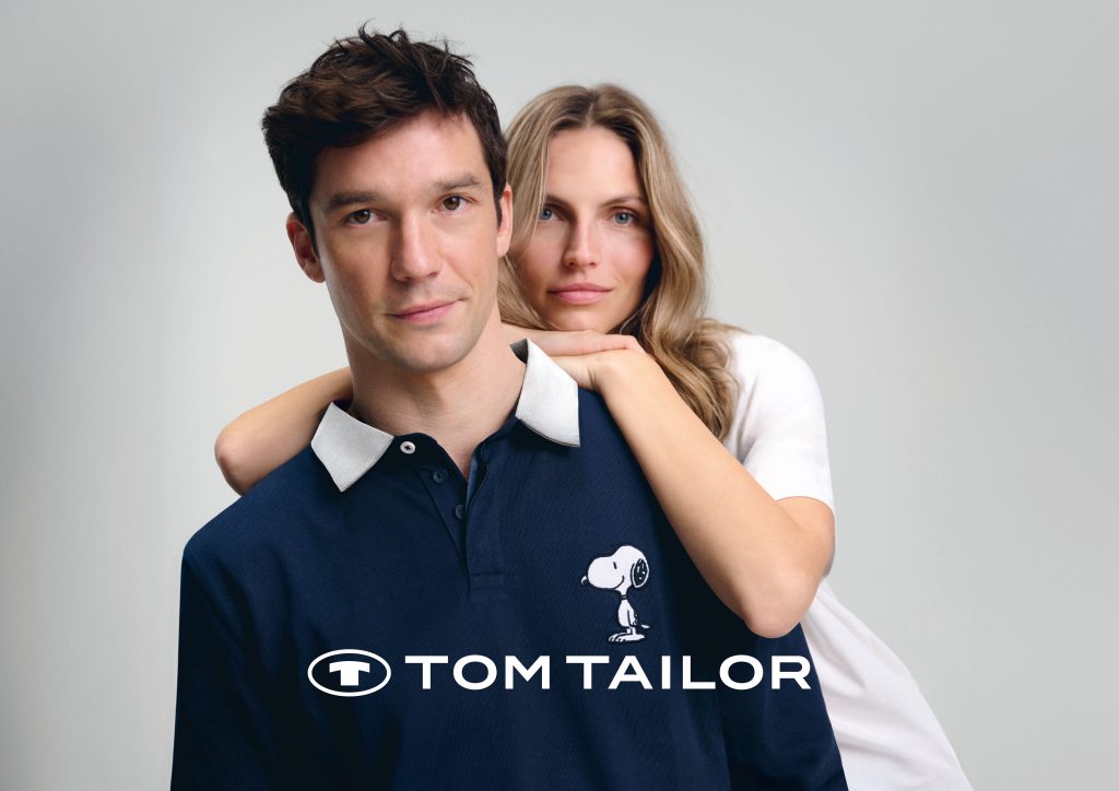 Tom Tailor Kampagnenbild: Mann in dunkelblauem Snoopy-Polohemd und Frau.
